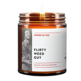 brown amber jar. lit candle. label is "Flirty Weed Guy". It's a linen scented Smoke and Pet Odor Eliminating Candle. It is for sale at Virgins On Fire Candle Co. Great for weed smokers, pot smokers, and pet owners.