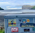 A sticker called quit your job and travel on a beach. 