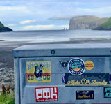 A sticker called quit your job and travel on a beach. 