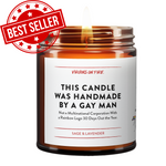Amber glass candle jar with 'Best Seller' red badge. White label shows 'This Candle Was Handmade By a Gay Man' with subtitle about not being a multinational corporation. Sage & Lavender scent by Virgins on Fire company. Small pride mascot icon