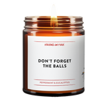 Amber glass candle jar from Virgins On Fire Candle Co., a gay-owned Brooklyn business. Label reads, "Don't Forget the balls." It is a peppermint & eucalyptus scented candle. 