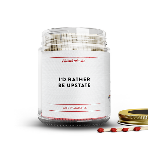 Clear glass jar filled with red tipped safety matches, featuring a minimalist label reading 'I'd rather be upstate."
