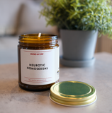 a candle on a table. the candle is called Neurotic Homosexual.