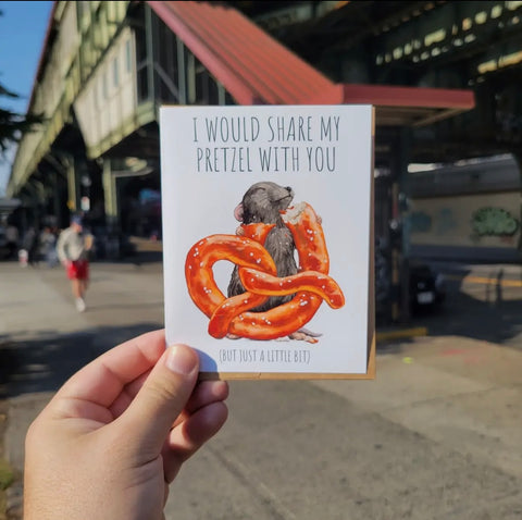 greeting card of nyc rat eating a pretzel. it says " I would share my pretzel with you but just a little bit"