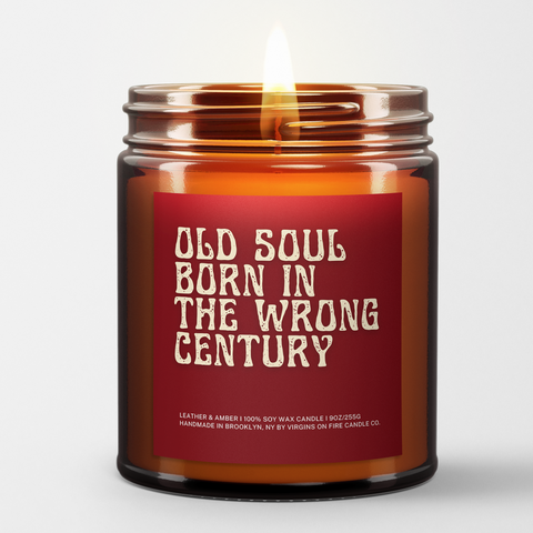 a lit amber candle with the name "Old Soul Born in the wrong century." Old font. Red background. White font.