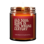 a lit amber candle with the name "Old Soul Born in the wrong century." Old font. Red background. White font.