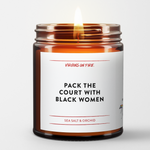 this candle is named "pack the court with black women". simple minimalist label. brown amber jar. lit. sea salt and orchid scented.