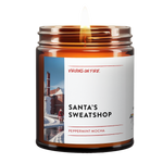 Peppermint mocha scented candle with satirical 'Santa's Sweatshop' theme. Features snowy industrial landscape photo and handcrafted by LGBTQ+ owned Virgins on Fire Candle Co. in Brooklyn
