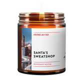 Peppermint mocha scented candle with satirical 'Santa's Sweatshop' theme. Features snowy industrial landscape photo and handcrafted by LGBTQ+ owned Virgins on Fire Candle Co. in Brooklyn
