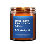 lit amber jar candle. blue background. it says, "some boys paint their nails, get over it." white eucalyptus scented.