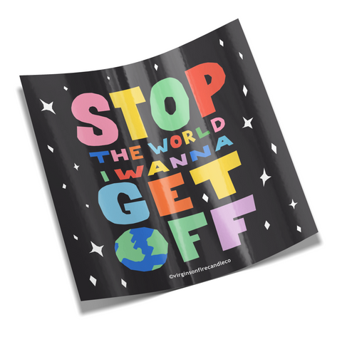 Colorful sticker design from Virgins on Fire featuring rainbow lettering on black background that reads 'Stop The World I Wanna Get Off' with playful earth illustration and stars. Made by LGBTQ+ owned Brooklyn candle company.