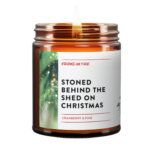 a burning candle - cranberry and pine scented - called Stoned Behind The Shed On Christmas. There's christmas pine on the left.