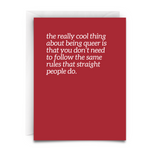 A greeting card - red - white white font - and white envelope that says - the really cool thing about being queer is that you don't need to follow the same rules that straight people do.