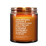 Candle jar with a quote on an orange label against a white background