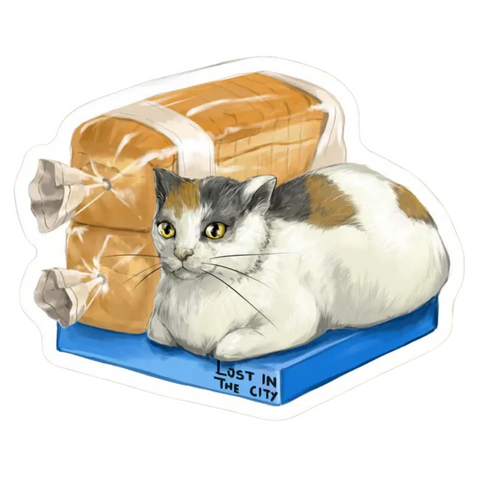 BODEGA CAT BREAD STICKER. A white and brown and gray cat sitting next to loaves of bread.