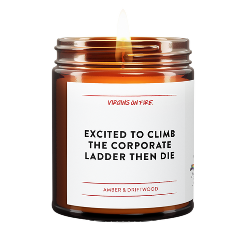 Lit soy wax candle in brown amber jar with the text, "Excited to Climb the Corporate Ladder then die." Amber and Driftwood scent. From Virgins On Fire Candle Co., a gay-owned small business in Brooklyn, NY.