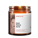 the emo prom date candle from virgins on fire candle co in brooklyn ny. raspberry and vanilla fragrance. safe fragrances and 100% soy wax. gay owned candlemaker. features emo looking girl under a red filter. lit candle. brown amber jar.