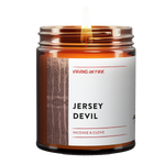 an amber jar candle called, "Jersey Devil" This New Jersey Candle is from Virgins On Fire Candle Co. It is incense and clove scented. It features a creepy photo of a swamp in black and white.