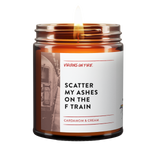 Virgins on Fire brand scented candle in amber glass jar, 'Scatter My Ashes on the F Train' scent featuring cardamom and cream fragrance. White label with vintage subway train photo background.