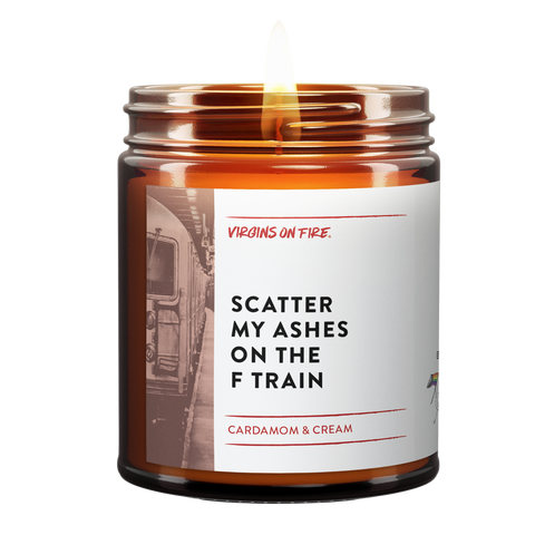 Virgins on Fire brand scented candle in amber glass jar, 'Scatter My Ashes on the F Train' scent featuring cardamom and cream fragrance. White label with vintage subway train photo background.